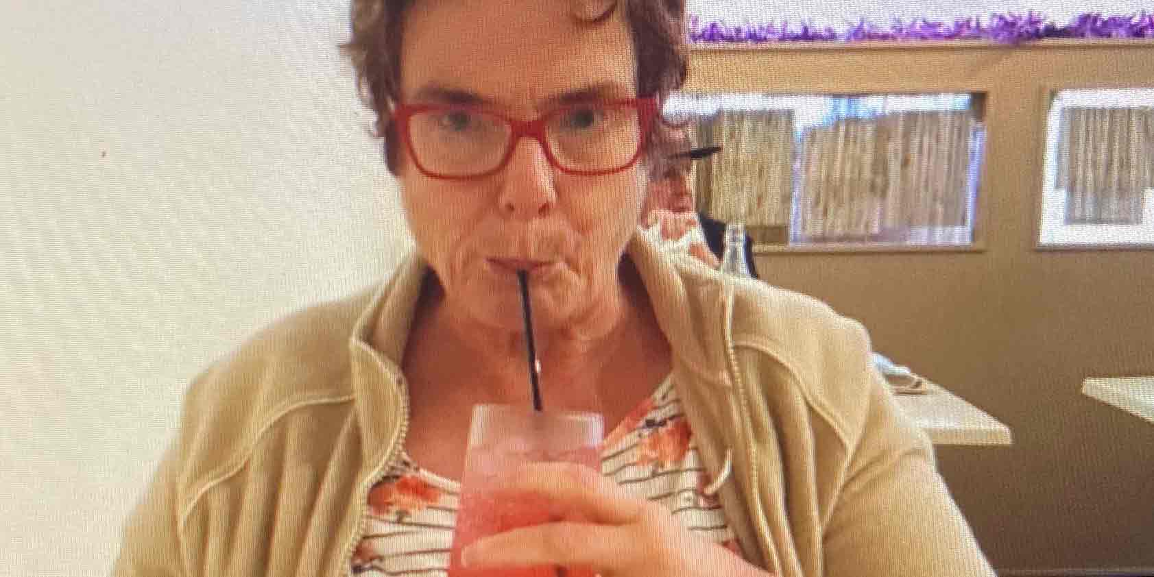 A woman drinking a drink out of a straw.