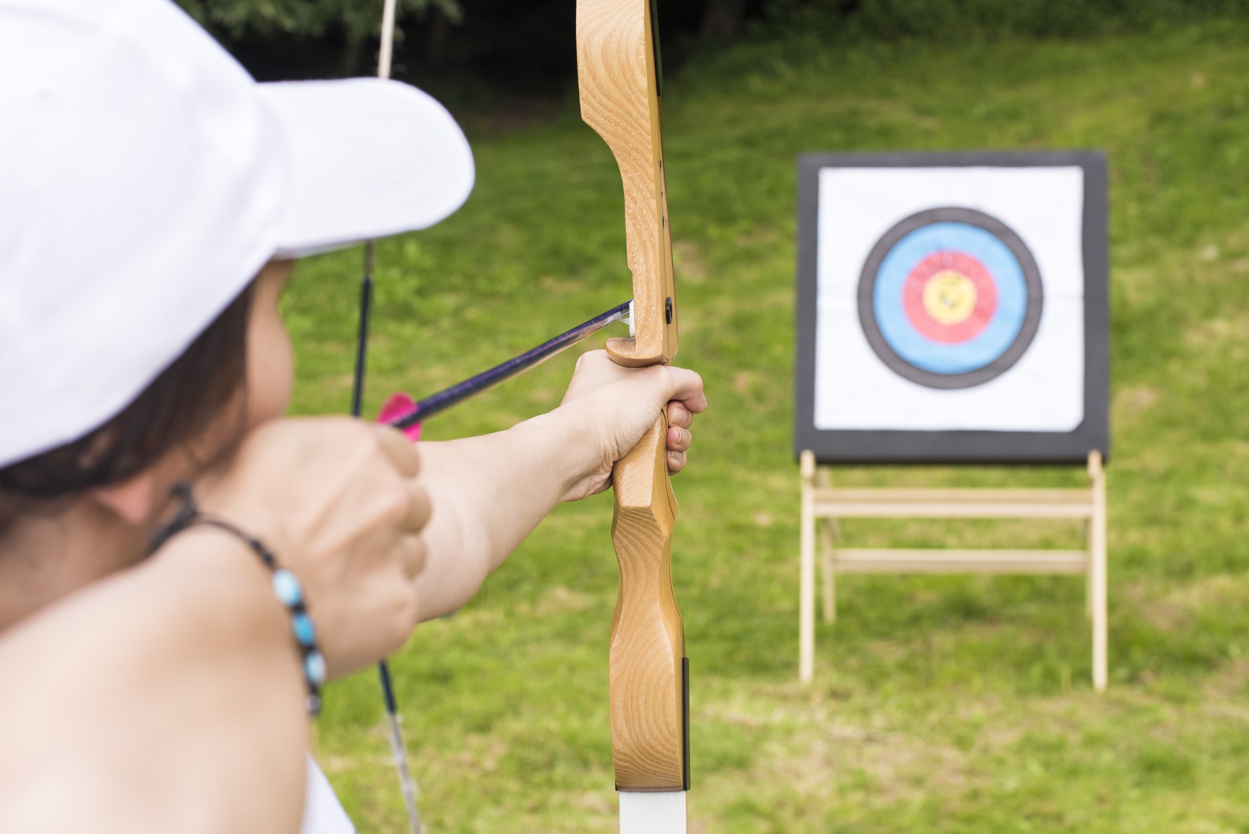 A young female archer holding his bow aiming at a target - sport and recreation concept