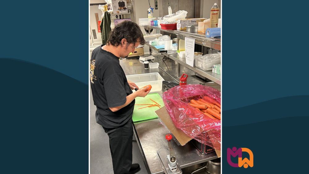 Pat peeling carrots in the commercial kitchen at Club Maitland City