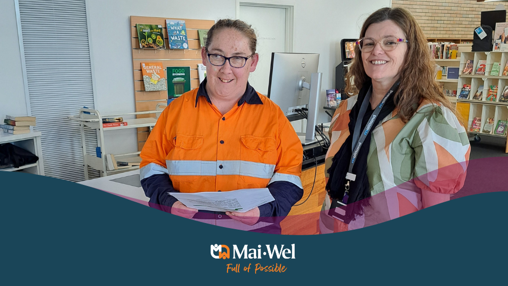 Women standing together smiling in library for library book delivery.