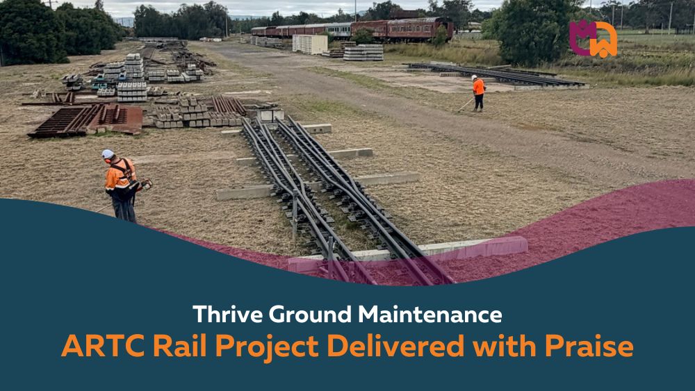 Two Thrive Ground Maintenance workers in high visibility gear work across a large open rail storage yard in Denman, with rail sleepers, steel structures, and tracks visible across the site. Text overlay reads "Thrive Ground Maintenance: ARTC Rail Project Delivered with Praise."