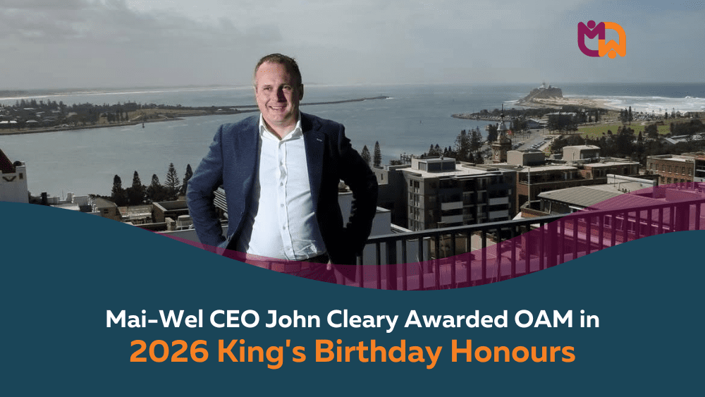Mai-Wel CEO John Cleary stands smiling on a rooftop overlooking Newcastle's coastline and city centre, with the Newcastle lighthouse visible in the background. Text overlay reads "Mai-Wel CEO John Cleary Awarded OAM in 2026 King's Birthday Honours."