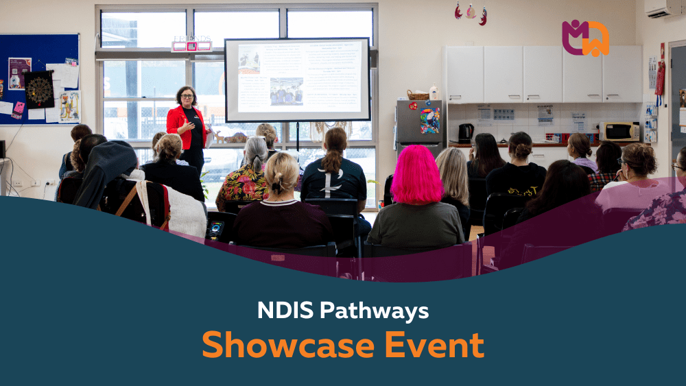 Mai-Wel Chief Participant Officer Jenny Cappellacci presents to a room full of seated attendees at the NDIS Pathways Showcase Event, with a projected presentation visible on the screen behind her.