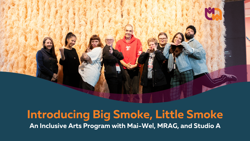 Group photo of people standing together against a golden textured backdrop, smiling and posing playfully. Below the photo, a teal banner with a curved purple edge reads "Introducing Big Smoke, Little Smoke: An Inclusive Arts Program with Mai-Wel, MRAG, and Studio A" in orange and white text, with the Mai-Wel icon in the top right corner.